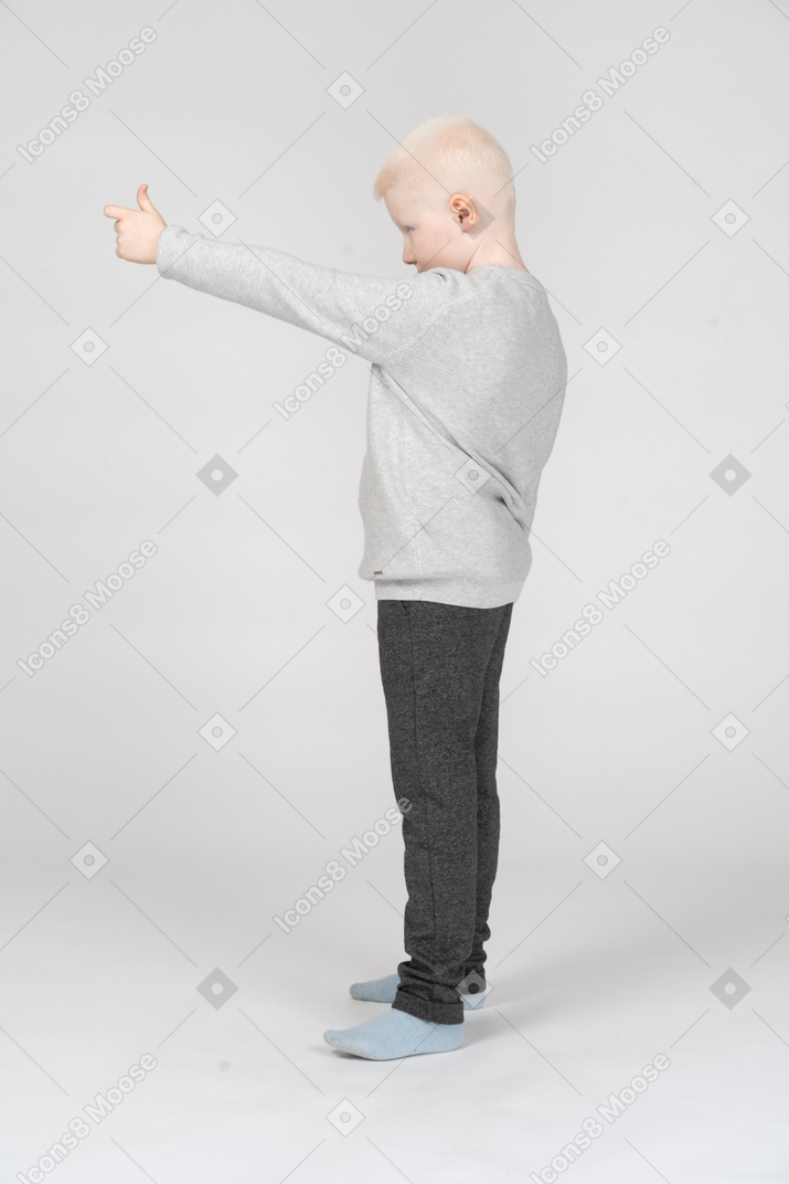 親指を立てる少年の側面図