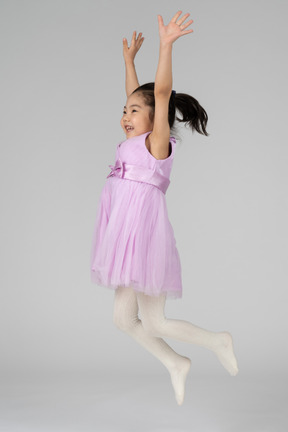 점프하는 핑크 드레스에 행복한 소녀