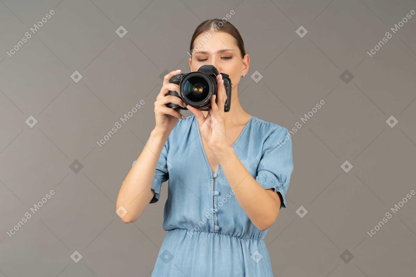 Vista frontal de uma jovem com vestido azul tirando uma foto