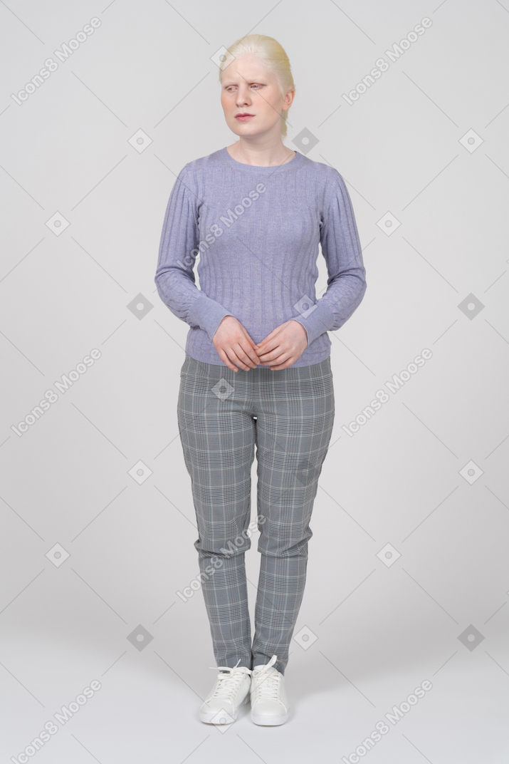 Vista frontal de una mujer rubia con ropa informal mirando a un lado