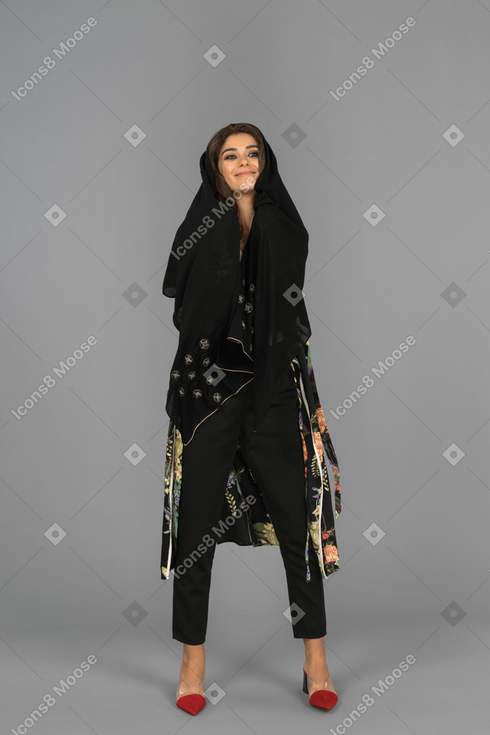 Cheerful arab woman wrapped in black headscarf