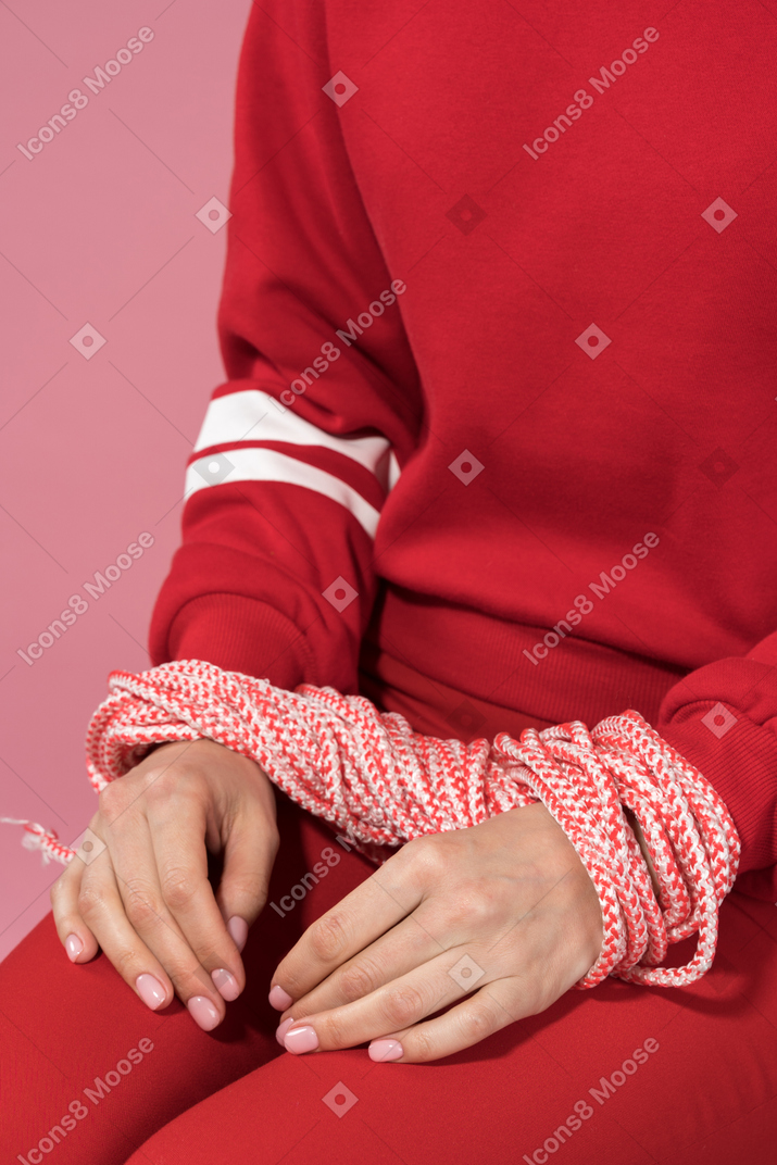 A female sitting with tied hands
