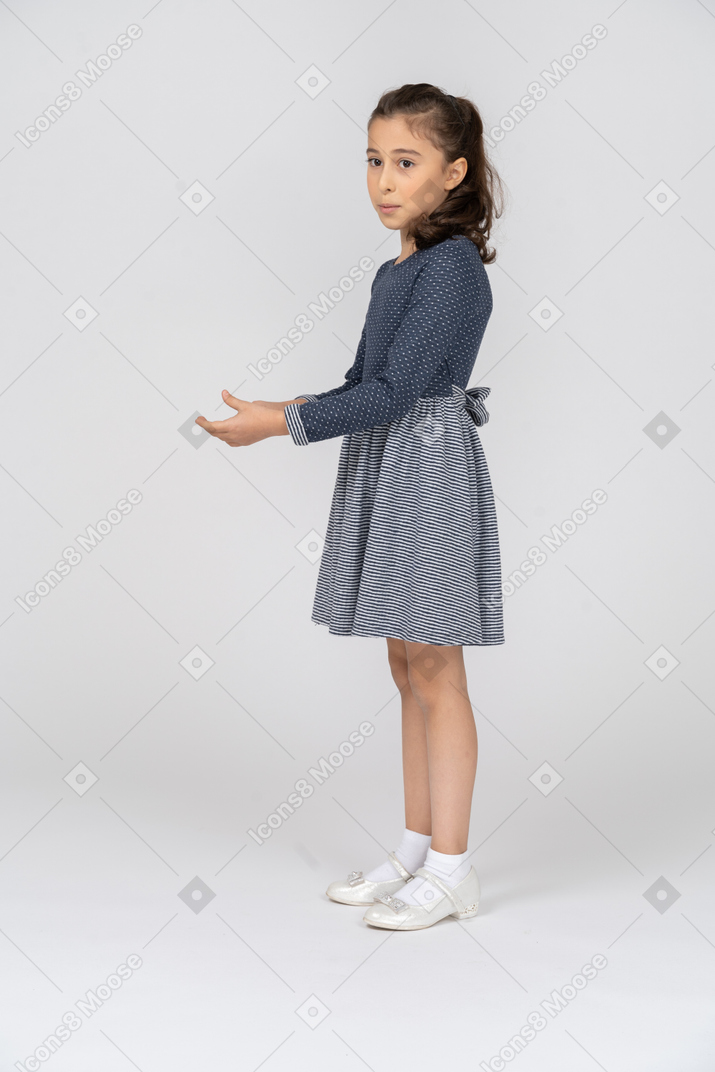 Side view of a girl holding hands in front of her with a surprised expression