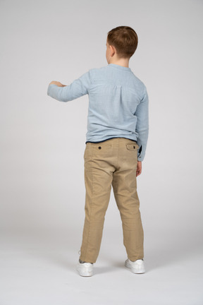 Back view of a boy pointing with finger