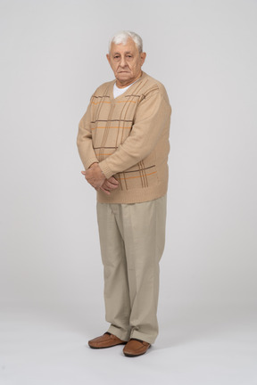 Front view of an old man in casual clothes looking at camera