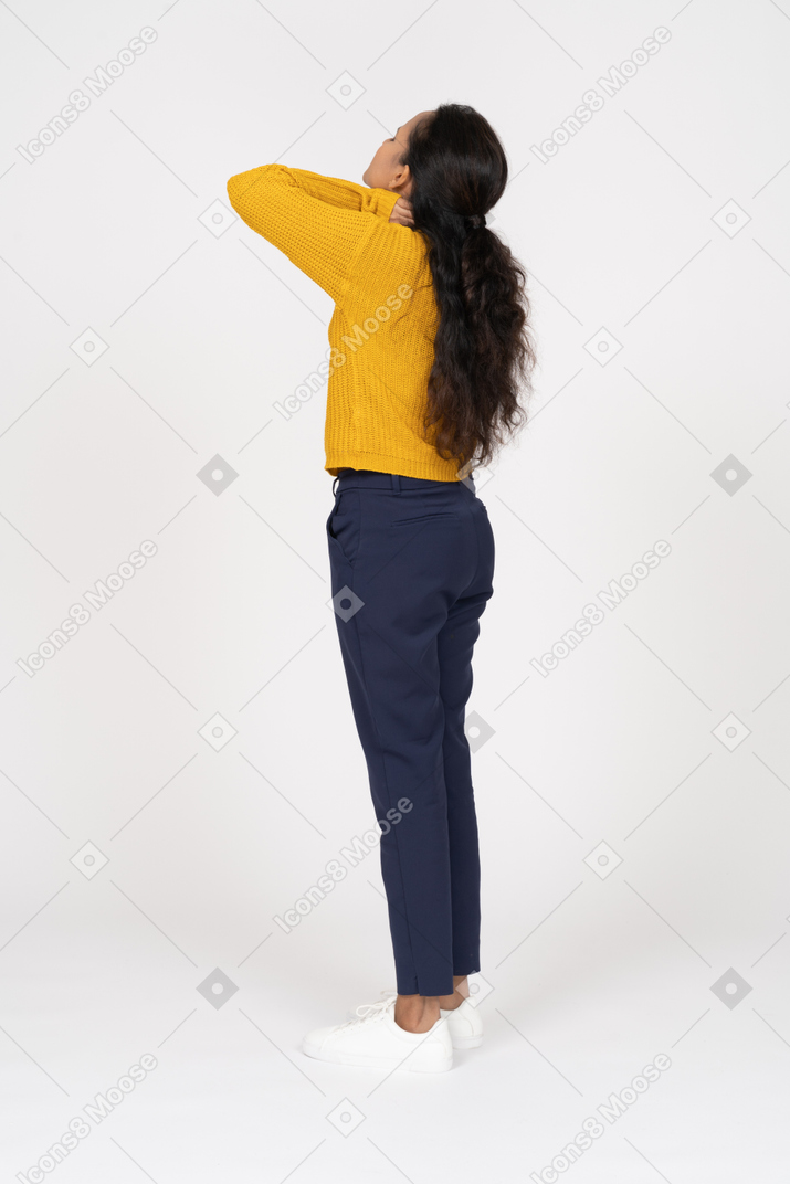 Vista lateral de una niña en ropa casual que sufre de dolor de cuello