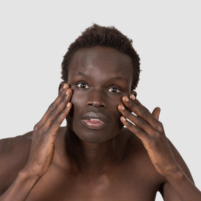 A black man is putting his hands on his face