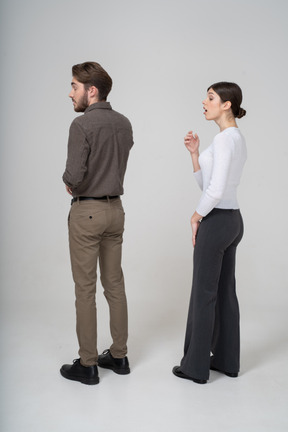 一对打呵欠的年轻夫妇，在办公室服装中的四分之三后视图