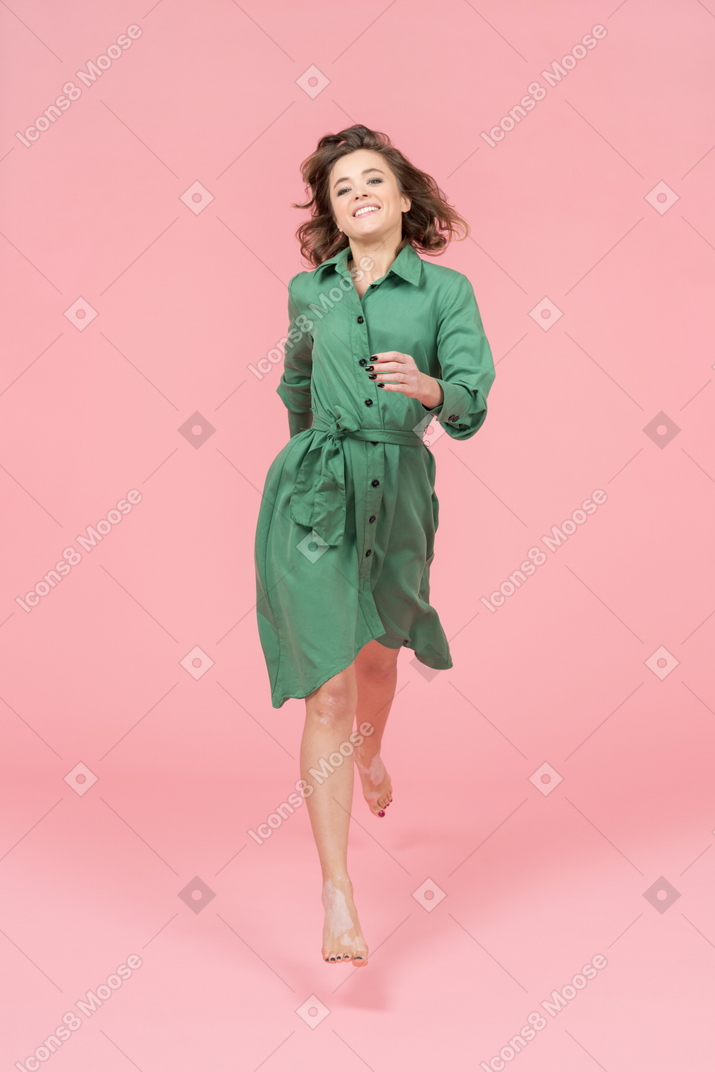 Una giovane donna allegra che cammina verso una macchina fotografica