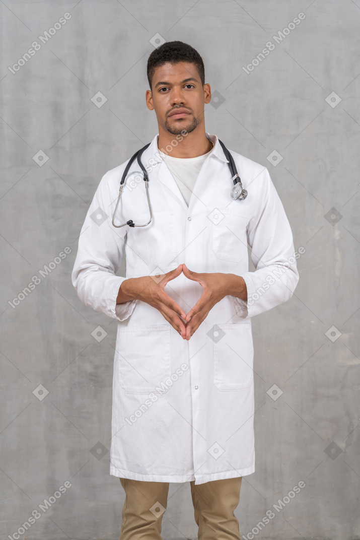 Doctor steepling his fingers while looking at camera