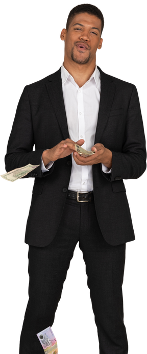 Front view of a young man in black suit wasting money