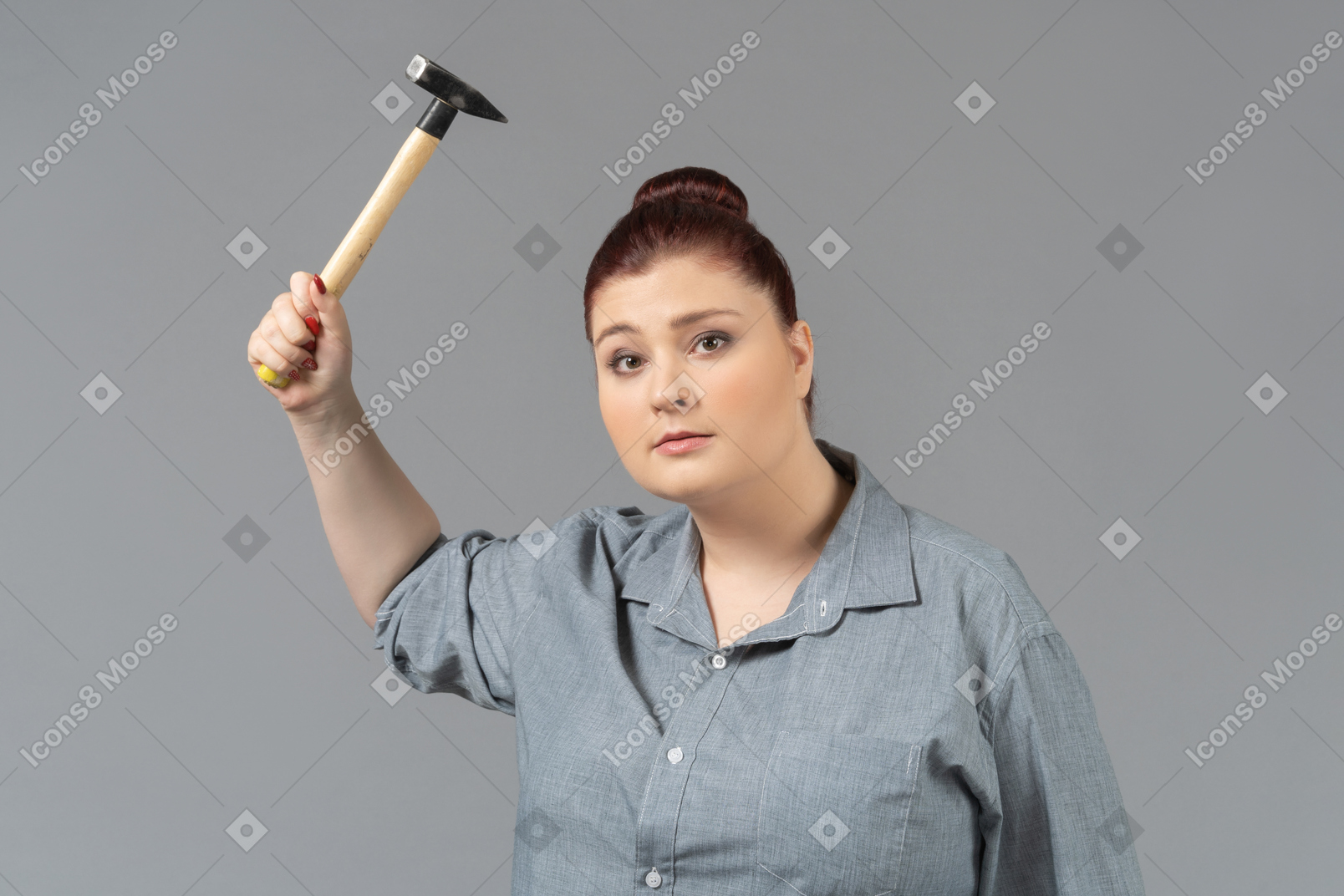 Jovem mulher ameaçando com um martelo