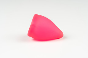 Pink menstrual cup over white background
