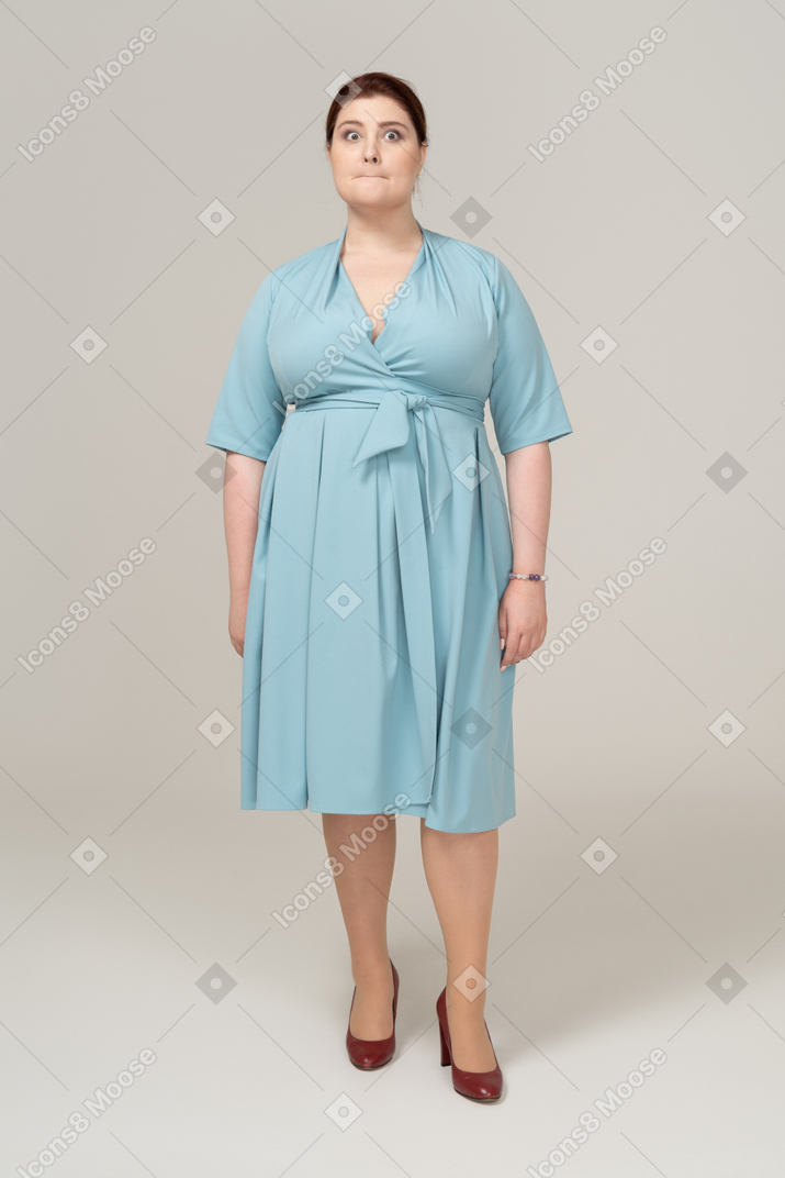 Front view of a woman in blue dress making faces