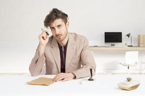 A man sitting at a desk with a pen and paper