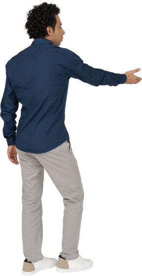 Rear view of a man in casual clothes giving a hand