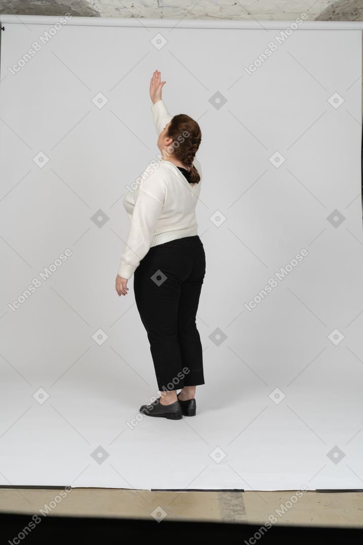 一个胖女人的侧视图，穿着休闲服，手臂高举