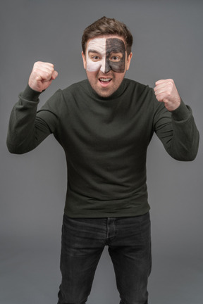 Front view of a screaming male football fan clenching fists