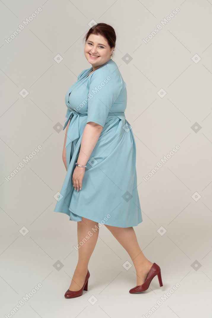 Woman in blue dress posing in profile