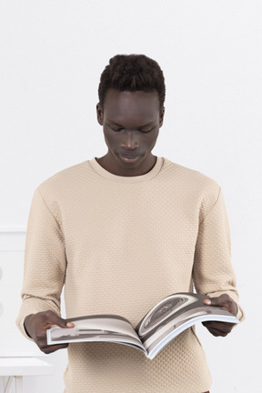 A man reading a book in a white room