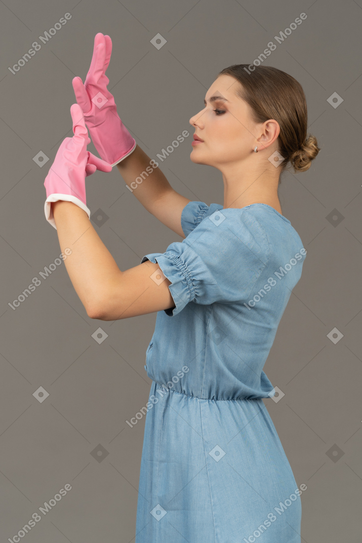 Portrait of a young woman raising hands in latex gloves