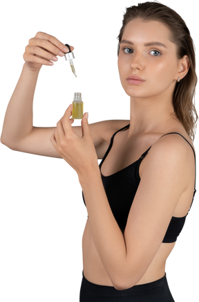 Side view of a young woman using face serum