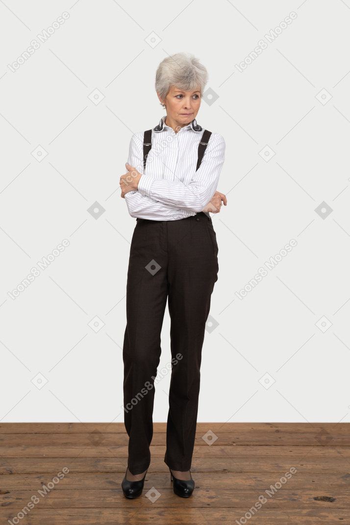 Vista frontale di una vecchia signora in abiti da ufficio attraversando le mani