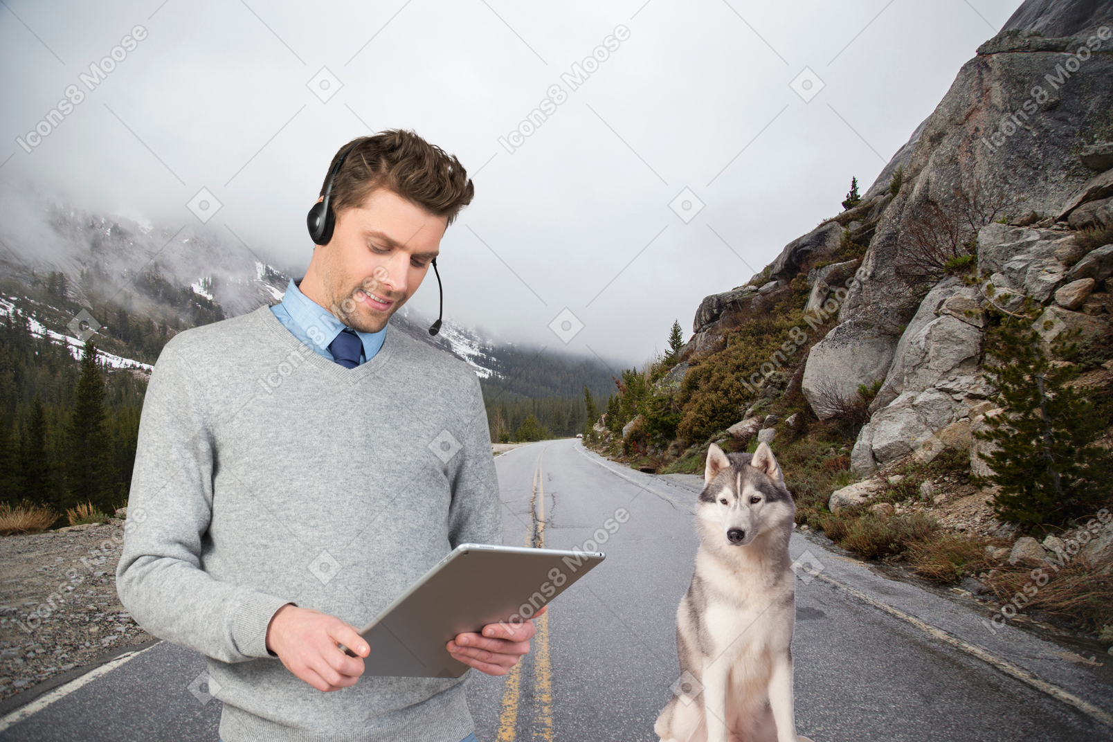 Mann, der remote auf seinem ipad arbeitet, während er mit seinem hund wandert