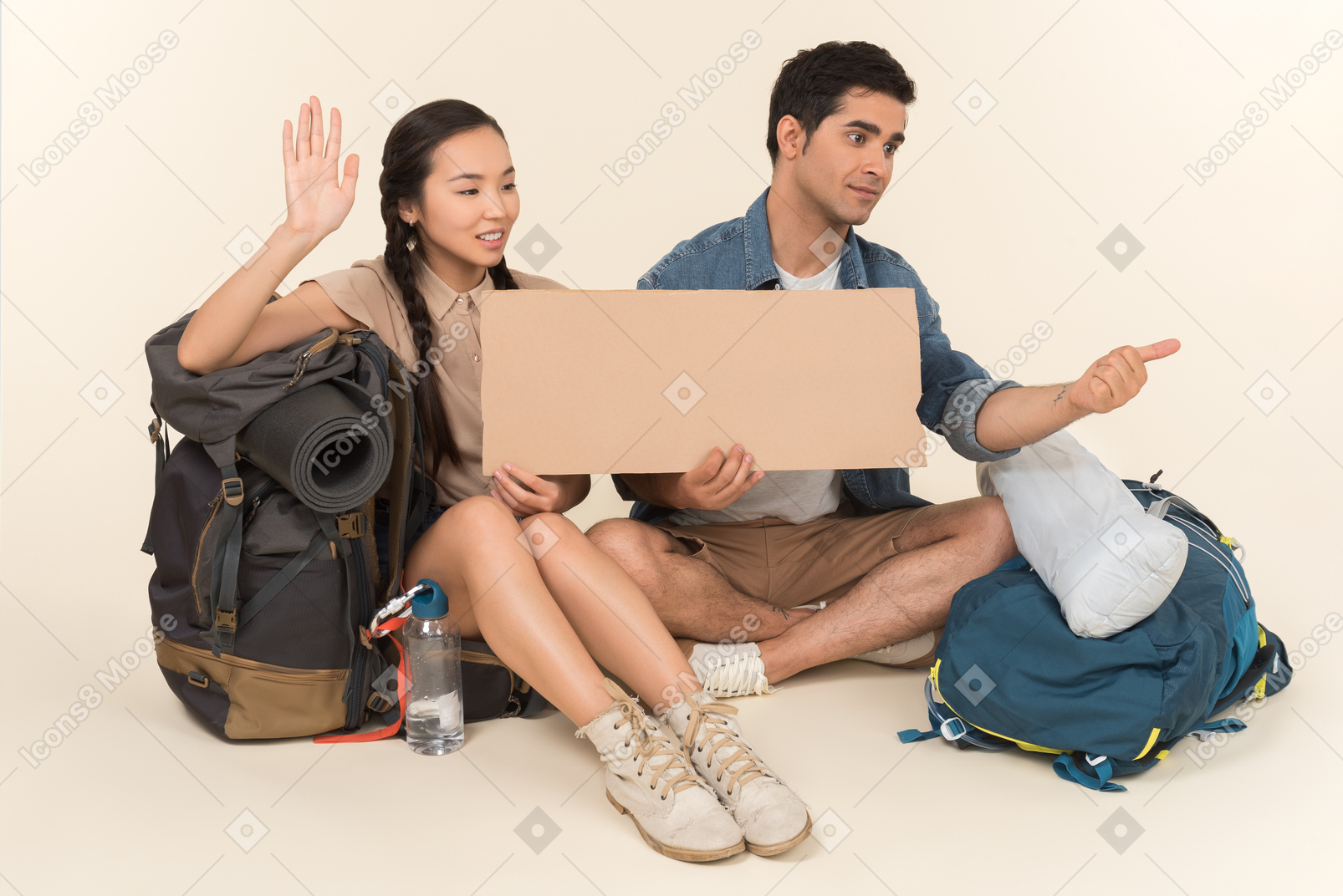 Jeune couple interracial montrant signe d'auto-stop assis sur des sacs à dos