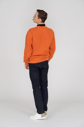 Jeune homme en sweat-shirt orange debout