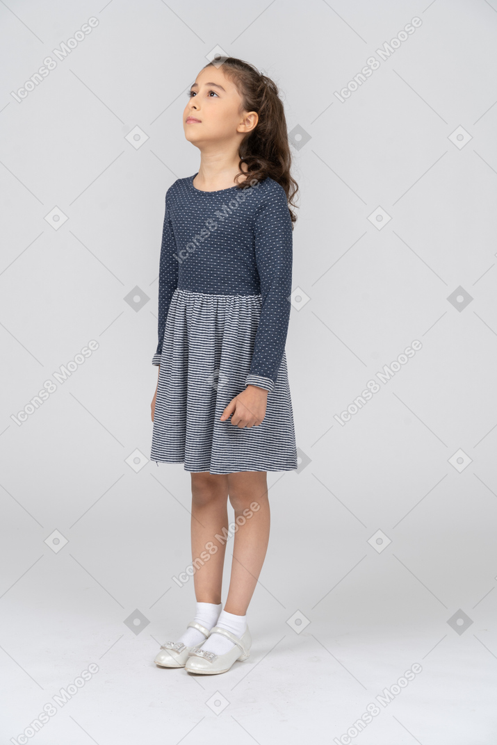 Vista frontal de una niña mirando hacia arriba