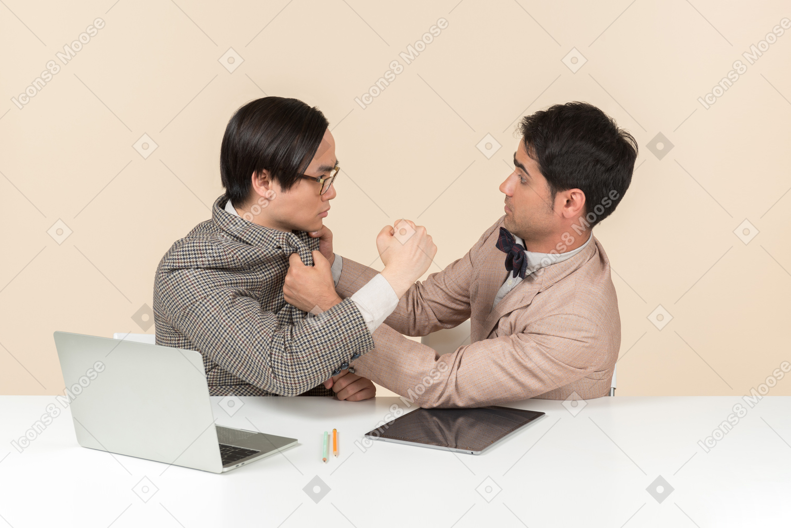 Two young nerds sitting at the table and punching each other into the face