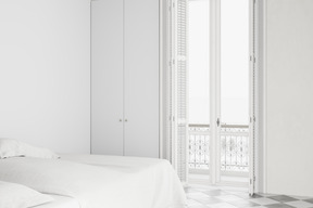 White bedroom with a balcony