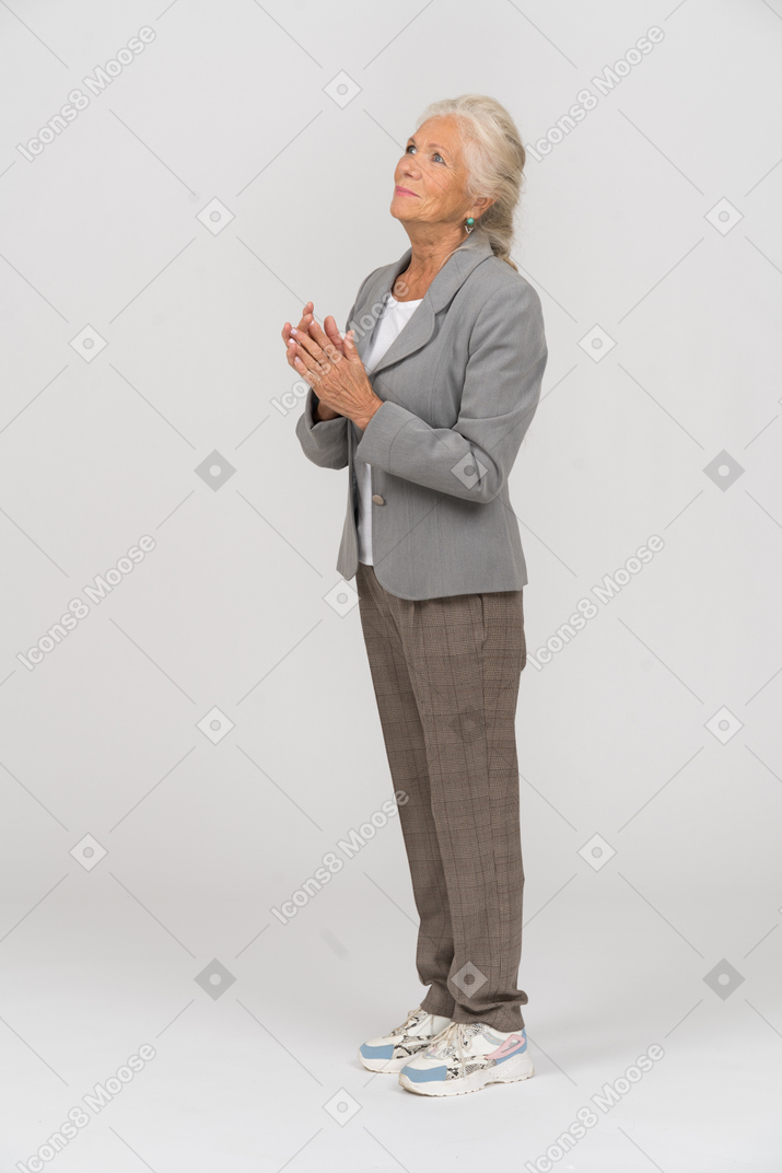 Side view of a happy old lady in suit looking up