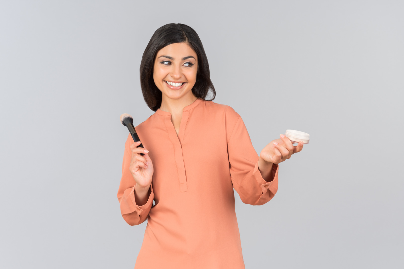 Indian woman holding face powder and powder brush
