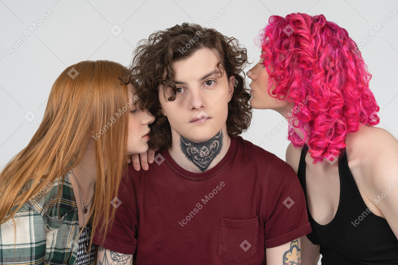 Two girls kissing a young man with a tattoo on his neck