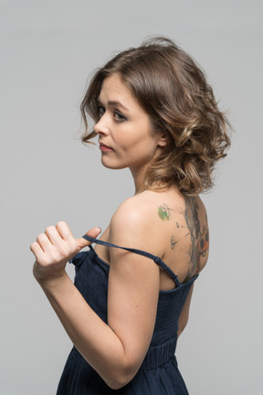 Donna con la schiena tatuata che si spoglia