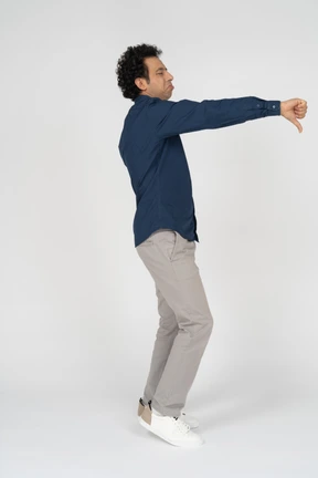 Side view of a man in casual clothes showing thumb down