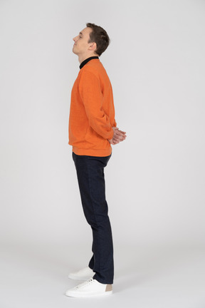 Young man in orange sweatshirt standing