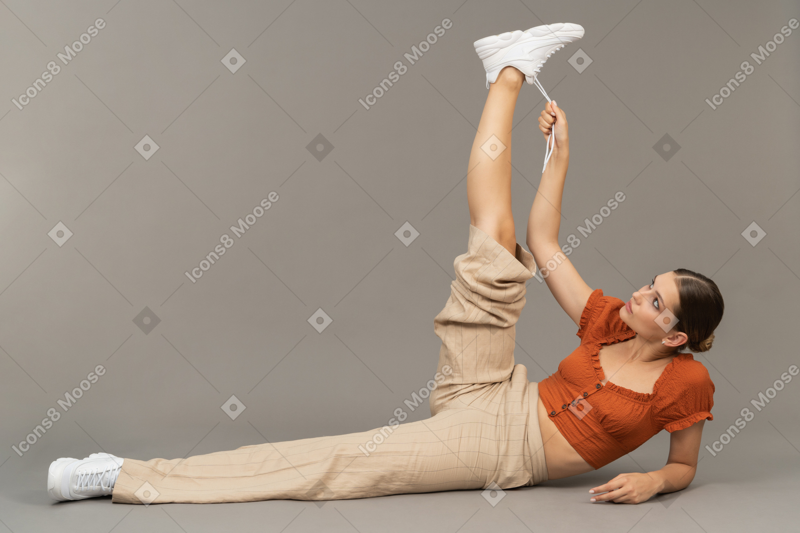 Giovane donna che tiene i lacci con la gamba tesa