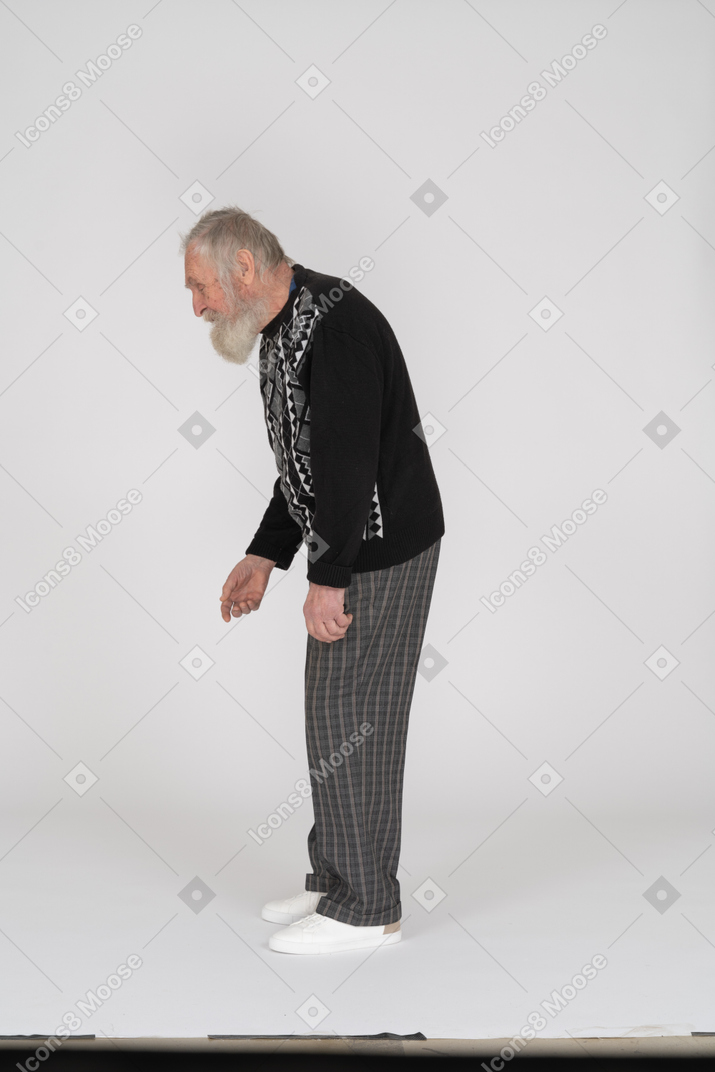 Side view of old man bending down and speaking to someone