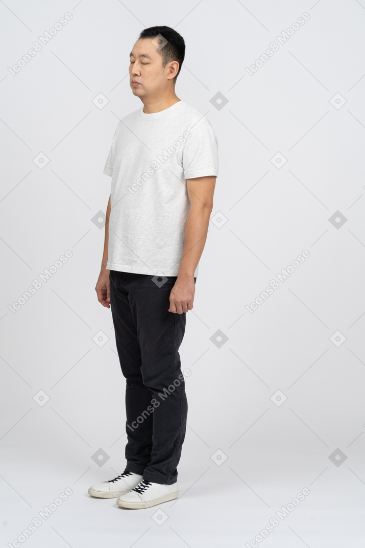 Man in casual clothes standing with closed eyes