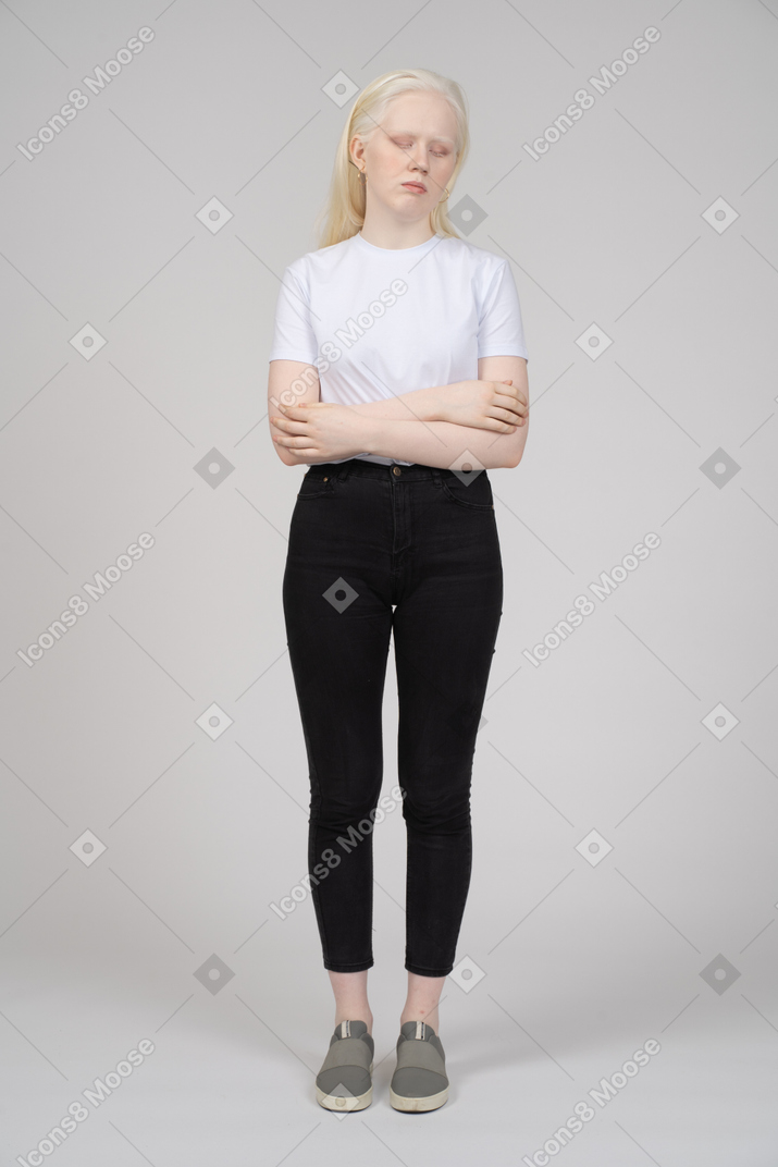 Pensive jeune femme debout avec les bras croisés