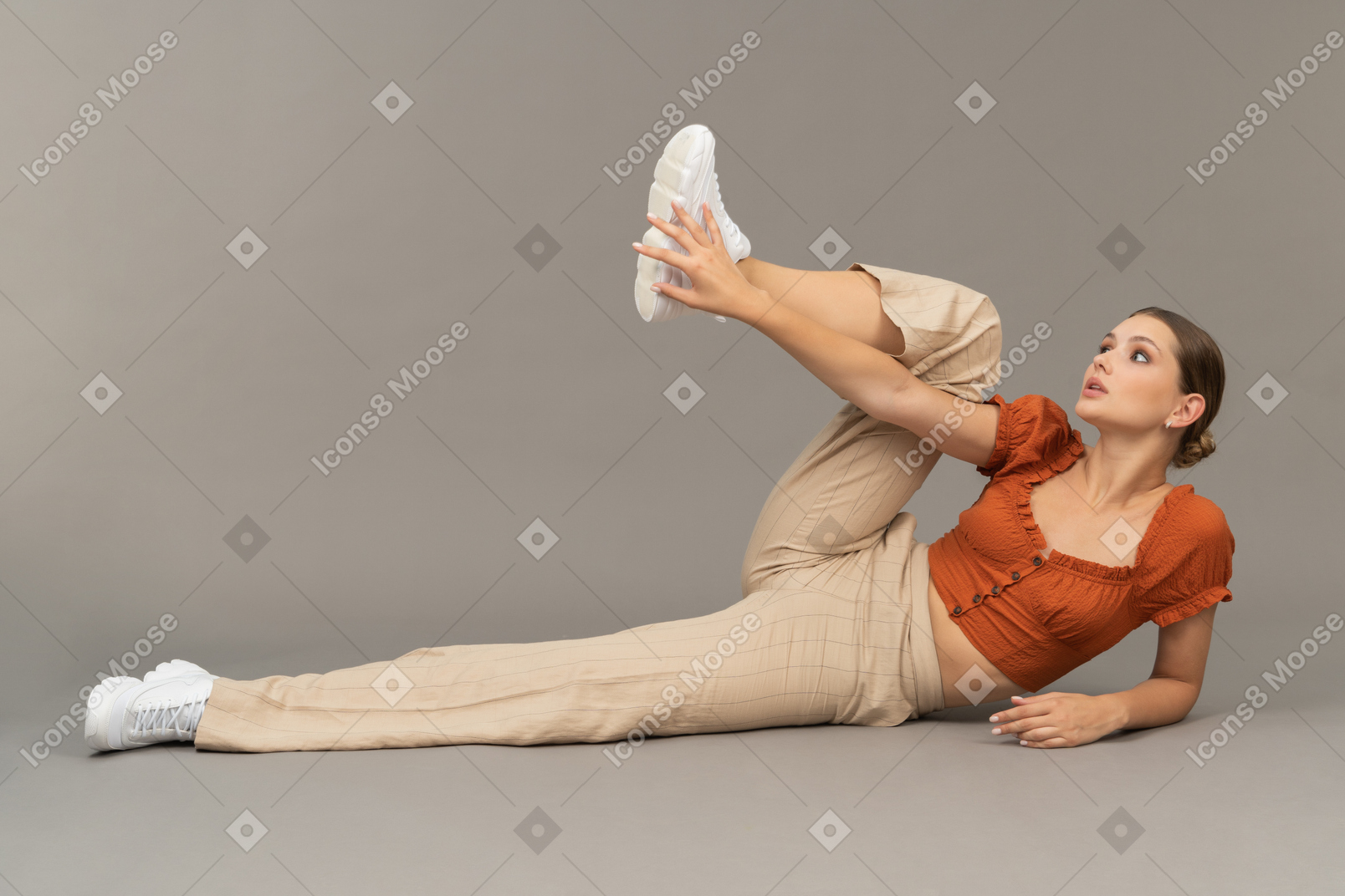 Young woman lies down and holds her leg