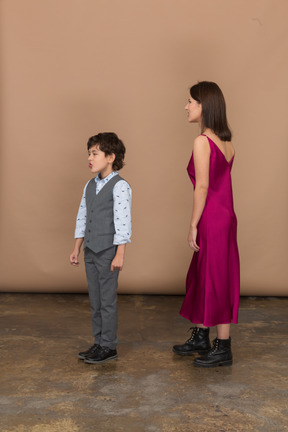 プロフィールに立っている若い女性と小さな男の子
