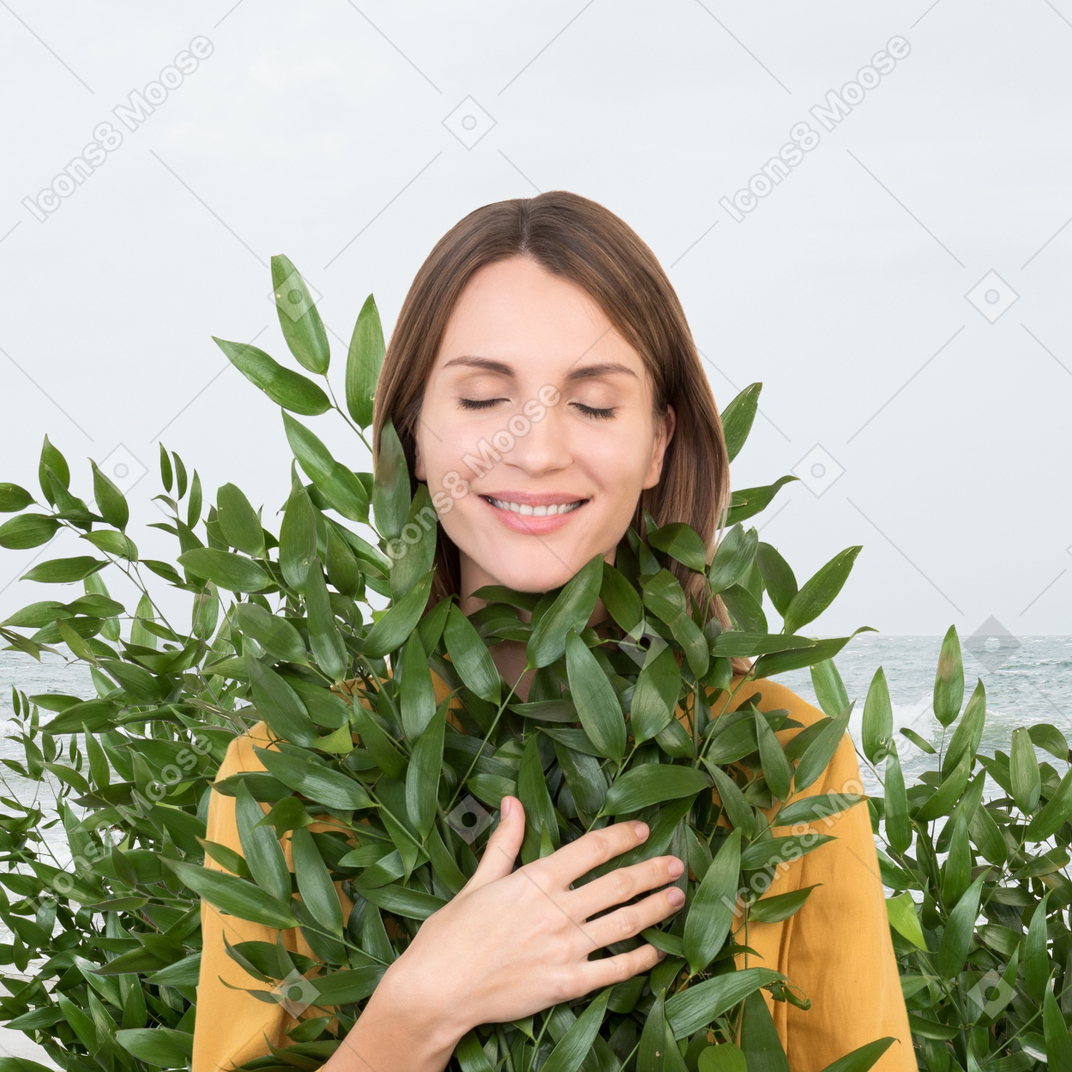 A woman holding a plant close to her
