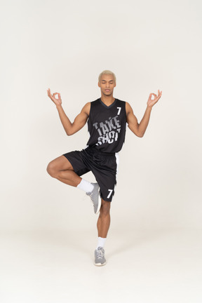 Front view of a meditating young male basketball player