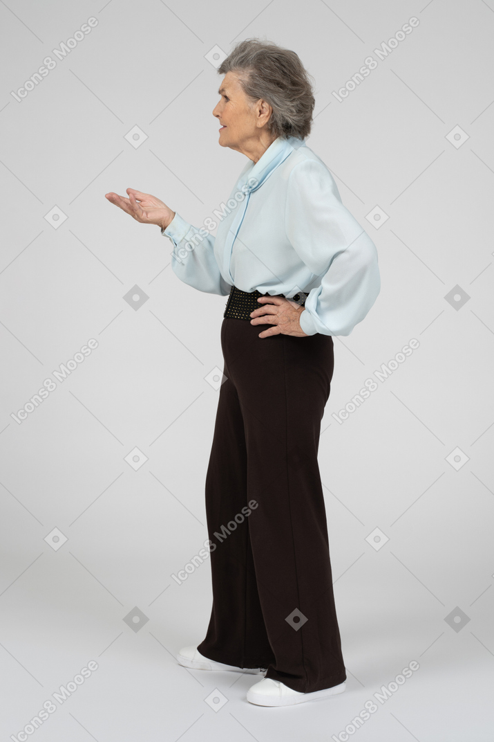 Side view of an old woman gesturing in question