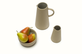 Two ceramic jugs and a bowl of pears