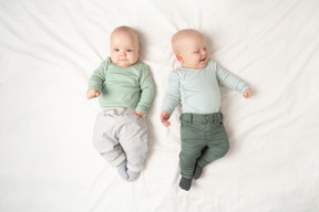 Babies twins lying on the back next to each other